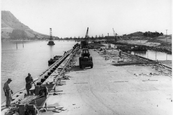 Construction of the first 373 metres. On 30 November 1953, The Hon W S Goosman, Minister of Works, drove the first pile. The Government built and financed the wharf and the Harbour Board repaid the capital cost, plus interest, over 30 years.